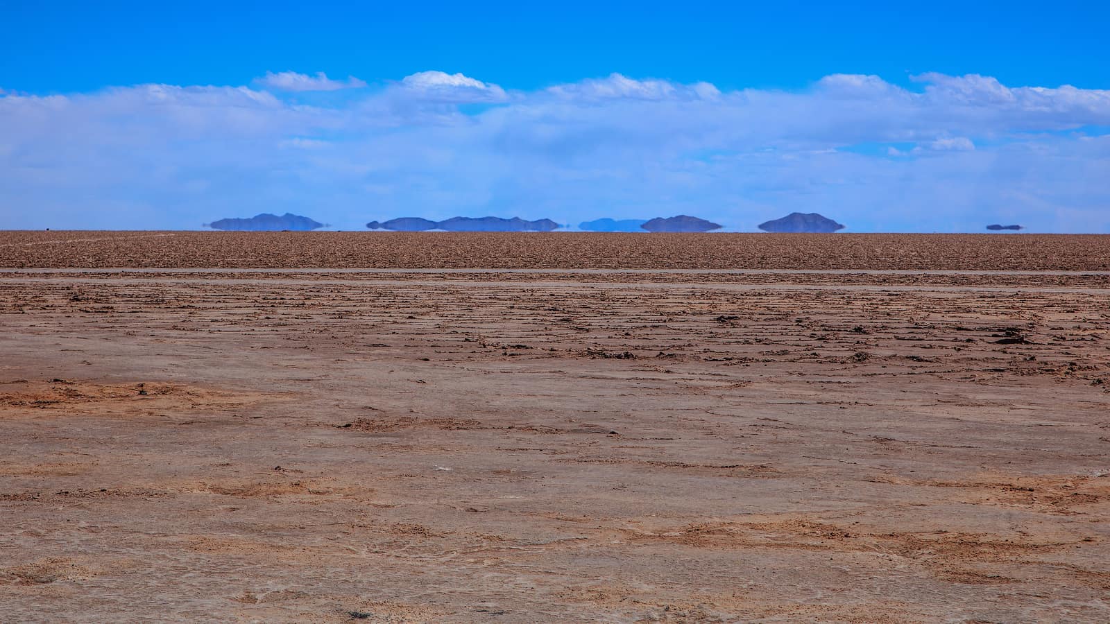 Distant hills appearing to float above the salt surface of the Salar de Uyuni